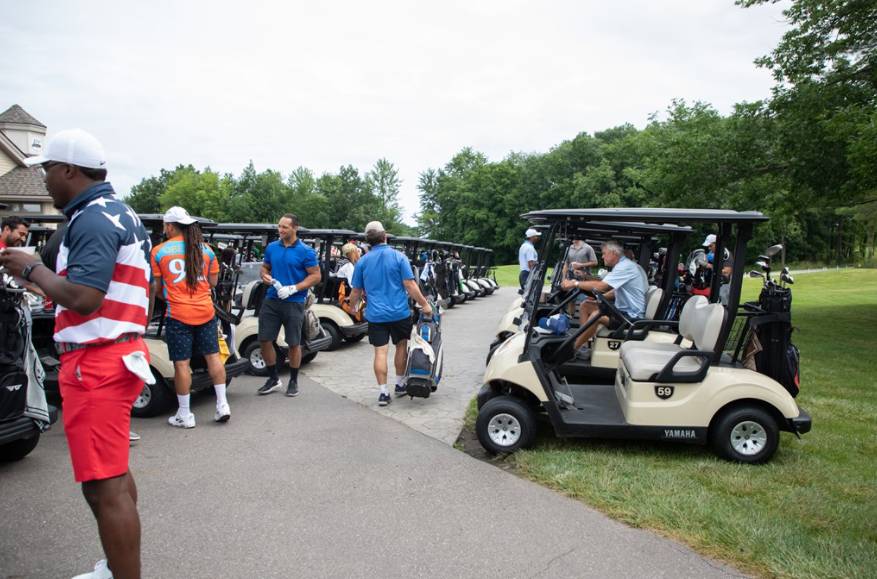 Group of alumni by golf carts